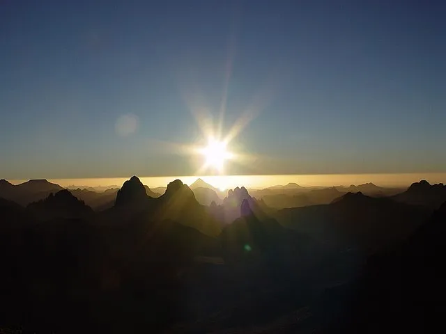 Die Sonne von der Tag-Nacht-Grenze aus gesehen (Sonnenaufgang über dem Hoggar im Süden Algeriens)