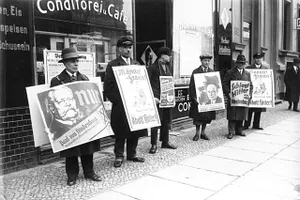Kandidatenplakate vor einem Berliner Wahllokal am zweiten Wahltag, dem 10. April 1932: Hindenburg, Hitler, Thälmann, noch einmal Thälmann, Hindenburg und Hitler