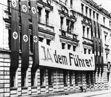 Schulhaus in Fürth, mit Fahnen versehen anlässlich der Volksabstimmung über die Vereinigung der Ämter des Reichspräsidenten und des Reichskanzlers am 19. August 1934. Amtliches Ergebnis im Reich: 89,9 Prozent Zustimmung