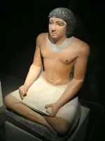 Seated statue of an Egyptian scribe holding a papyrus document in his lap, found in the western cemetery at Giza, Fifth dynasty of Egypt (25th to 24th centuries BC)