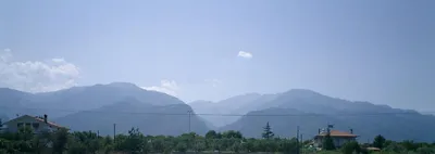 Das Olymp-Gebirge in Griechenland von Osten her fotografiert. Das Tal im Vordergrund zeigt die einzige Zufahrt in den von dem Gebirge umringten Nationalpark. - Stefan Reitzner - 2003 - Wikipedia