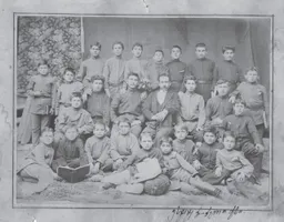 Schüler und Lehrer der Kirchenschule von Gori, Russisches Kaiserreich (1892). Iosseb Dschughaschwili befindet sich als Vierter von links in der oberen Reihe. Es handelt sich um die älteste öffentlich bekannte Fotografie von Stalin.